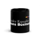 Black mug with the words "Gender Equality Means Business" printed in white. On the bottom to the right of those words is The SHE Mark logo in white with the words "The SHE Mark" below it. Above the main graphic is a line of five rectangles in the following color order: gold, ruby, teal, purple, and green.