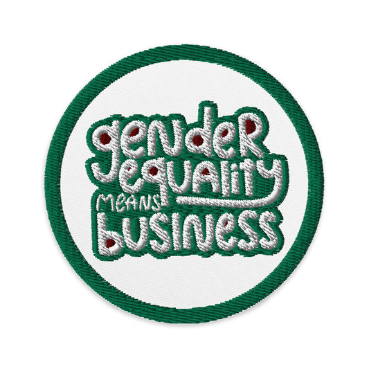 A white circular patch with a green embroidered border. The patch reads "gender equality means business." The words are white surrounded by a green border, and the spaces in each letter are filled with ruby.