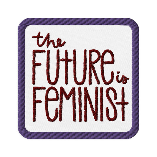 White square patch with a purple embroidered border. In the center of the square it says "the future is feminist" in ruby embroidery.
