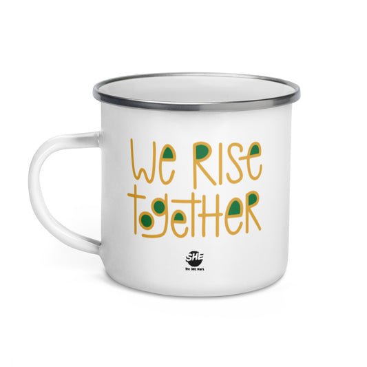 White enamel mug with a silver lip. Printed on the mug read "We rise together," in gold font with green filling in the spaces in the letters. Below the phrase is The SHE Mark logo in black, with "The SHE Mark" in black printed below the logo. This design is printed twice on the mug so it is visible regardless of which hand in which you hold the mug.