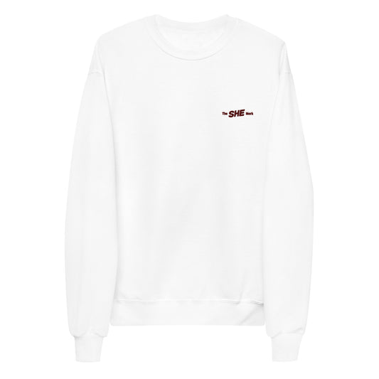 White crewneck sweatshirt with "the SHE Mark" embroidered on the left chest in black.